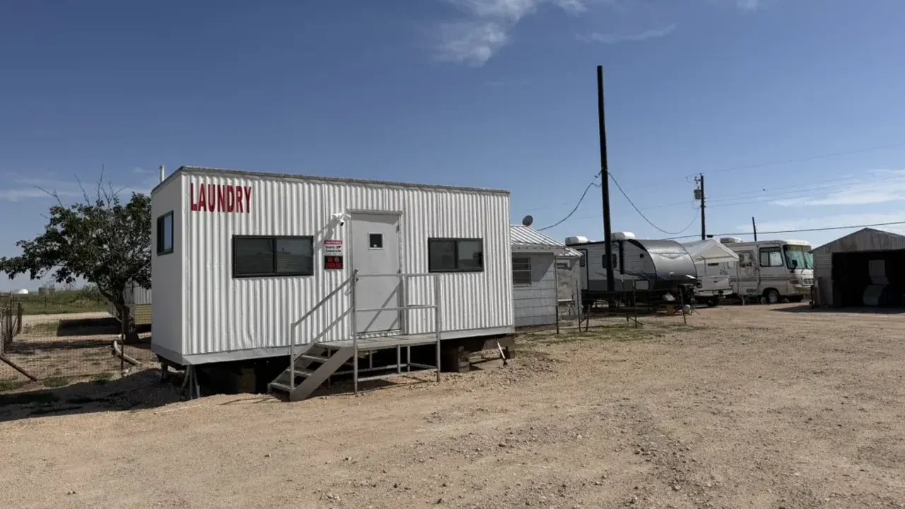On-site laundry building with a red LAUNDRY sign and steps at Goldsmith RV Park & Housing
